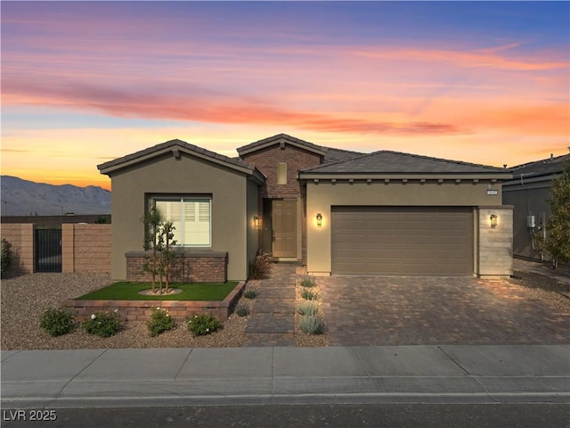 8668 Hartmont St, Las Vegas, NV 89166 - ranch-style home featuring decorative driveway, stucco siding, an attached garage, a mountain view, and a tile roof