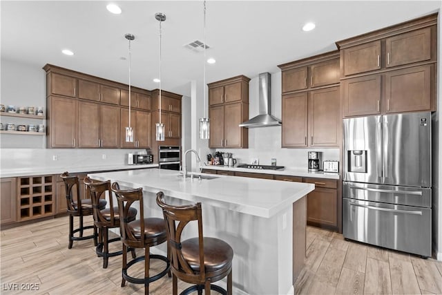 8668 Hartmont St, Las Vegas, NV 89166 - kitchen with appliances with stainless steel finishes, wall chimney exhaust hood, a sink, light countertops, and decorative light fixtures