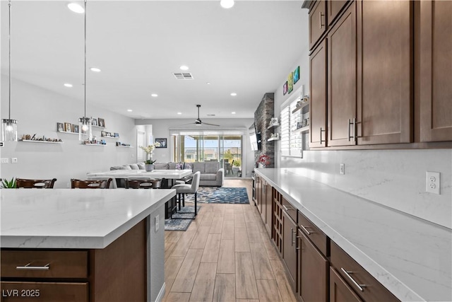 8668 Hartmont St, Las Vegas, NV 89166 - kitchen with ceiling fan, light wood finished floors, recessed lighting, open floor plan, and pendant lighting