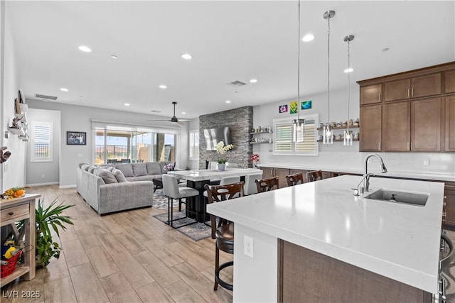 8668 Hartmont St, Las Vegas, NV 89166 - kitchen featuring a sink, a breakfast bar, a ceiling fan, light wood-style flooring, and recessed lighting