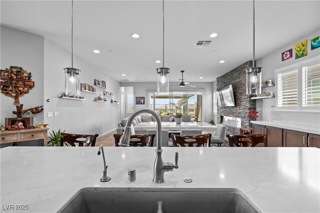 8668 Hartmont St, Las Vegas, NV 89166 - kitchen with a sink, a ceiling fan, recessed lighting, light stone counters, and hanging light fixtures