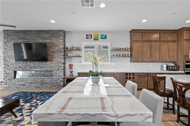 8668 Hartmont St, Las Vegas, NV 89166 - dining area featuring recessed lighting and a stone fireplace