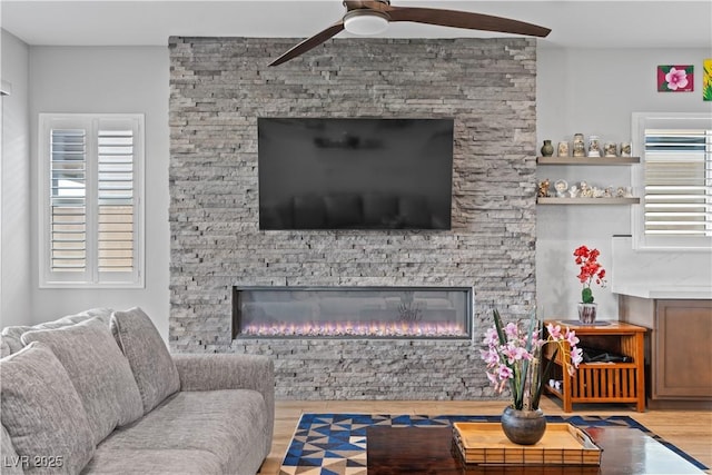 8668 Hartmont St, Las Vegas, NV 89166 - living room featuring ceiling fan, wood finished floors, a fireplace, and healthy amount of natural light