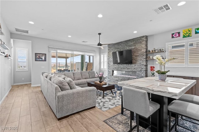 8668 Hartmont St, Las Vegas, NV 89166 - living room featuring a ceiling fan, light wood-style floors, a fireplace, recessed lighting, and baseboards