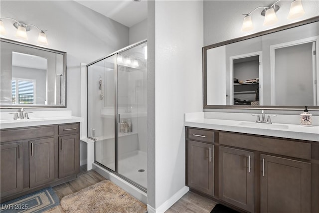 8668 Hartmont St, Las Vegas, NV 89166 - full bathroom with a shower stall, two vanities, and wood finished floors