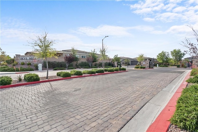8668 Hartmont St, Las Vegas, NV 89166 - view of decorative road featuring street lighting, curbs, a gated entry, a gate, and a residential view