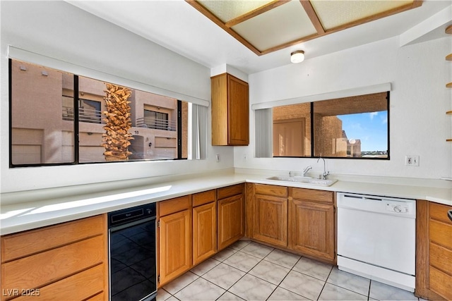 3827 Desert Marina Dr Unit 211, Laughlin, NV 89029 - kitchen featuring white dishwasher, a sink, brown cabinetry, light countertops, and light tile patterned floors