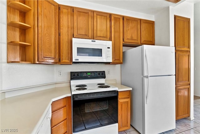 3827 Desert Marina Dr Unit 211, Laughlin, NV 89029 - kitchen with white appliances, light countertops, brown cabinets, and light tile patterned flooring