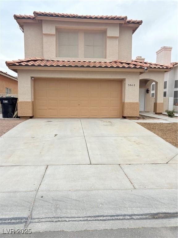 5040 Jacarilla Ln, North Las Vegas, NV 89031 - mediterranean / spanish-style house with a tile roof, a garage, concrete driveway, and stucco siding