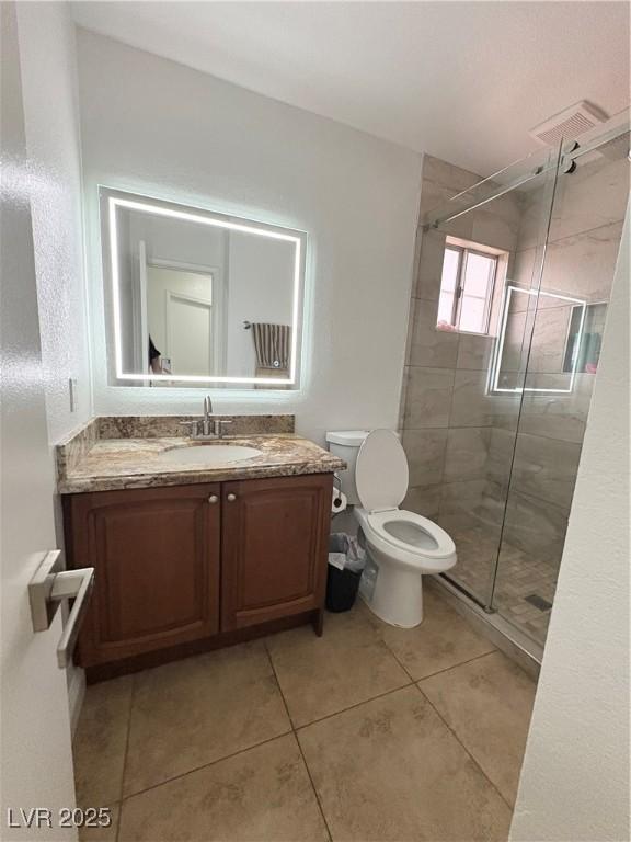 5040 Jacarilla Ln, North Las Vegas, NV 89031 - bathroom featuring vanity, toilet, a shower stall, and tile patterned floors