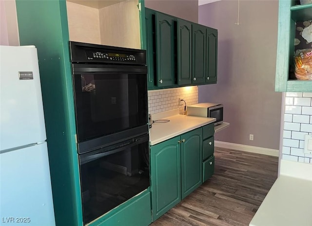 2855 Rice St, Logandale, NV 89021 - kitchen featuring green cabinets, freestanding refrigerator, light countertops, baseboards, and dark wood-type flooring