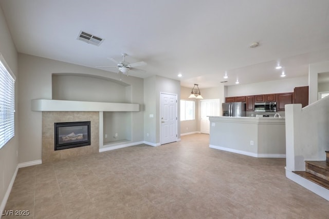 1554 Ward Frontier Ln, Henderson, NV 89002 - unfurnished living room with recessed lighting, a tile fireplace, ceiling fan, baseboards, and stairs