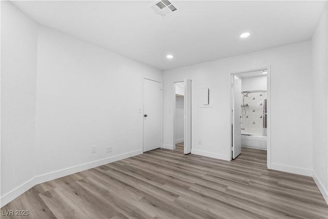 3923 Gogo Way Unit 106, Las Vegas, NV 89103 - unfurnished bedroom with wood finished floors, recessed lighting, baseboards, and connected bathroom