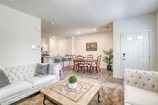 12728 Feathersong St, Henderson, NV 89044 - living area with light wood finished floors, baseboards, and recessed lighting