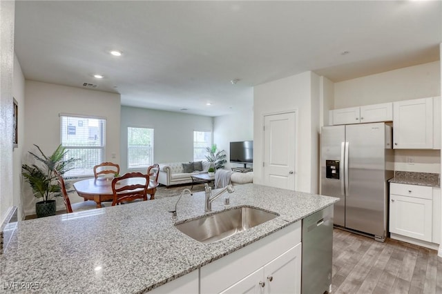 12728 Feathersong St, Henderson, NV 89044 - kitchen featuring stainless steel appliances, a sink, light wood finished floors, white cabinetry, and recessed lighting