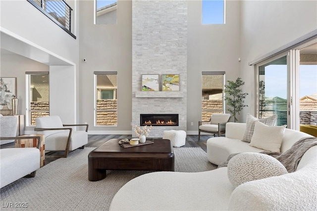 2890 Reverence Heights Ln, Las Vegas, NV 89138 - living room with a high ceiling, wood finished floors, healthy amount of natural light, a fireplace, and baseboards