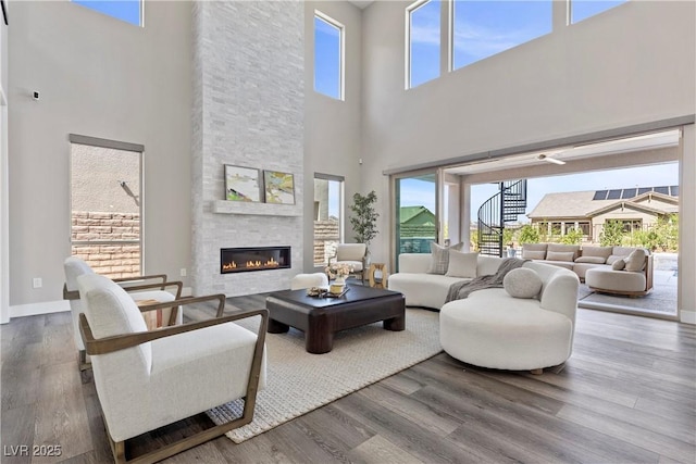 2890 Reverence Heights Ln, Las Vegas, NV 89138 - living area with a towering ceiling, wood finished floors, a stone fireplace, and baseboards