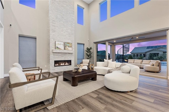 2890 Reverence Heights Ln, Las Vegas, NV 89138 - living area with a high ceiling, wood finished floors, a fireplace, and baseboards