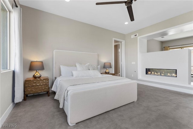 2890 Reverence Heights Ln, Las Vegas, NV 89138 - carpeted bedroom with a glass covered fireplace, recessed lighting, a ceiling fan, and baseboards