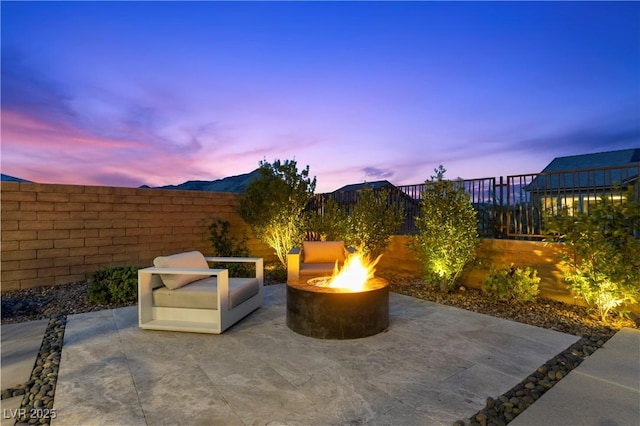 2890 Reverence Heights Ln, Las Vegas, NV 89138 - patio terrace at dusk featuring an outdoor fire pit, a patio, and a fenced backyard