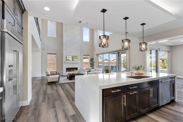 2890 Reverence Heights Ln, Las Vegas, NV 89138 - kitchen featuring a sink, appliances with stainless steel finishes, a fireplace, dark wood-style floors, and a high ceiling