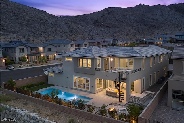 2890 Reverence Heights Ln, Las Vegas, NV 89138 - back of property at dusk featuring a residential view, stucco siding, a fenced backyard, and stairs