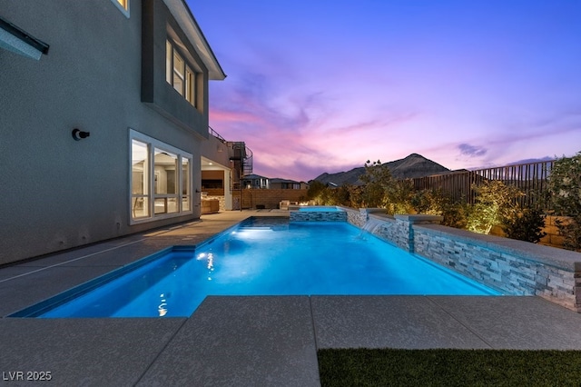 2890 Reverence Heights Ln, Las Vegas, NV 89138 - pool at dusk with a fenced backyard, a patio area, and a pool with connected hot tub