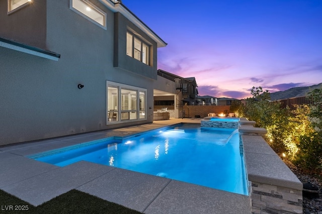 2890 Reverence Heights Ln, Las Vegas, NV 89138 - pool at dusk with a patio, a fenced backyard, and a pool with connected hot tub
