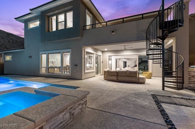 2890 Reverence Heights Ln, Las Vegas, NV 89138 - back of property at dusk with stairs, outdoor lounge area, an in-ground hot tub, a patio, and stucco siding