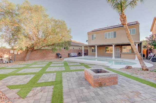 6826 Dovecote Ave, North Las Vegas, NV 89084 - back of house with an outdoor fire pit, a fenced backyard, and roof mounted solar panels