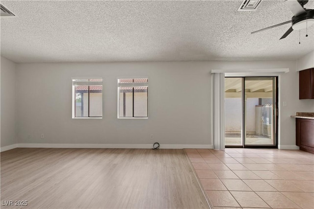 3936 Applecrest St, Las Vegas, NV 89108 - unfurnished room with healthy amount of natural light, a textured ceiling, a ceiling fan, light wood finished floors, and baseboards