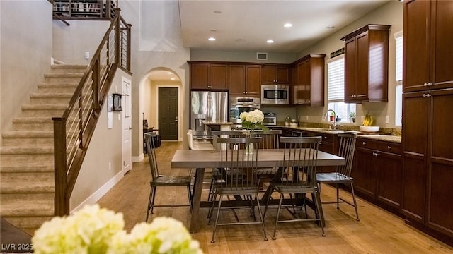 11731 Longworth Rd, Las Vegas, NV 89135 - kitchen with appliances with stainless steel finishes, arched walkways, light wood-style floors, recessed lighting, and a sink