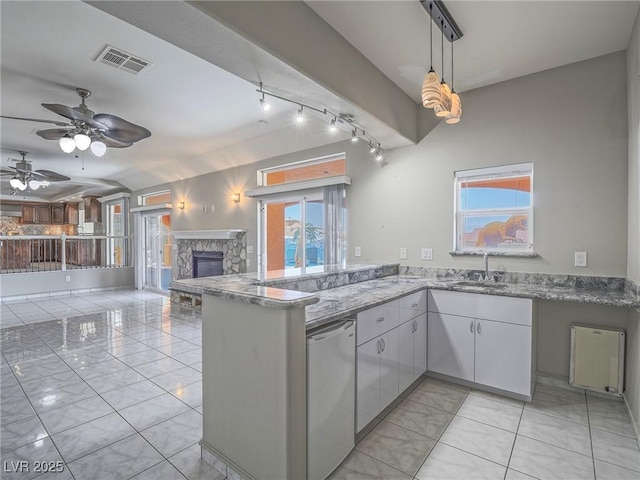 420 Dakar St, Henderson, NV 89015 - kitchen with stainless steel dishwasher, a sink, a peninsula, a fireplace, and light marble finish flooring