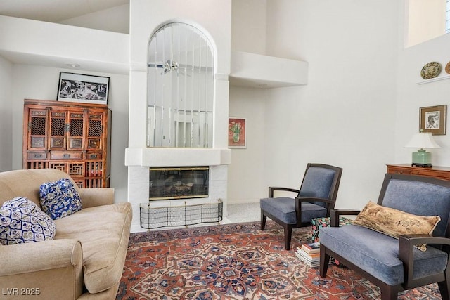 8236 Round Hills Cir, Las Vegas, NV 89113 - living area with carpet floors, a tiled fireplace, and a high ceiling