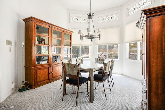 8236 Round Hills Cir, Las Vegas, NV 89113 - dining room featuring light colored carpet, a chandelier, a high ceiling, and baseboards