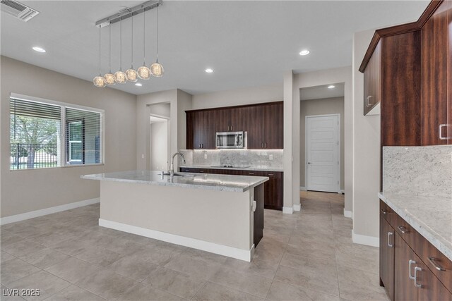 4829 E Beacon Ridge Dr, Pahrump, NV 89061 - kitchen with stainless steel microwave, decorative backsplash, black electric cooktop, baseboards, and recessed lighting