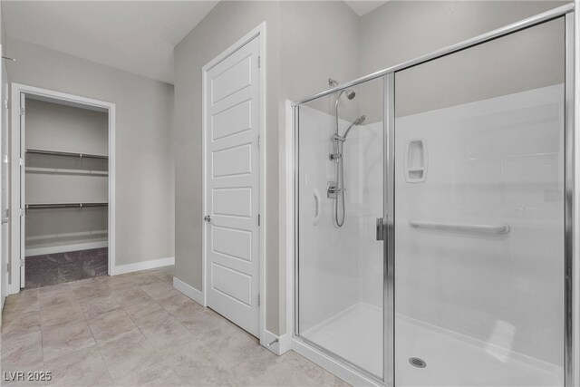 4829 E Beacon Ridge Dr, Pahrump, NV 89061 - bathroom featuring a stall shower, baseboards, and a spacious closet