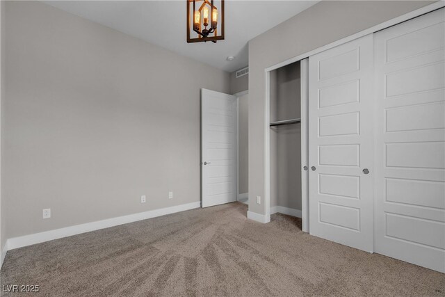 4829 E Beacon Ridge Dr, Pahrump, NV 89061 - unfurnished bedroom featuring carpet floors, a chandelier, a closet, and baseboards