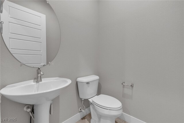 4829 E Beacon Ridge Dr, Pahrump, NV 89061 - bathroom featuring toilet, baseboards, and a sink