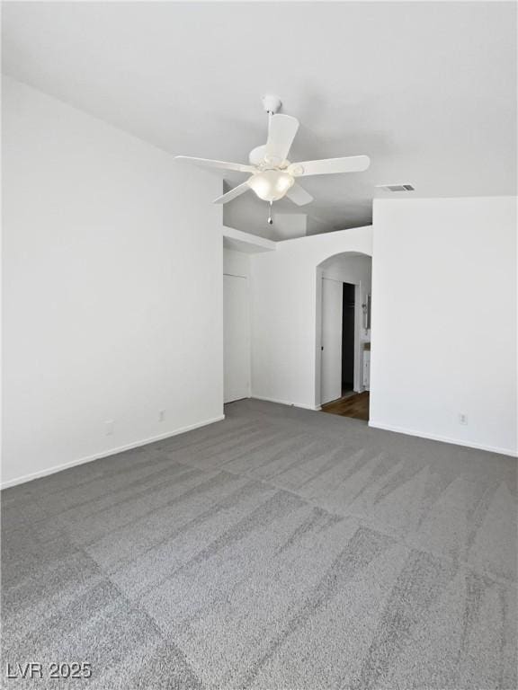 7524 Fencerow St, Las Vegas, NV 89131 - spare room featuring arched walkways, dark colored carpet, ceiling fan, and baseboards