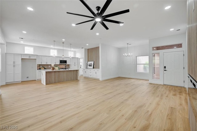 2353 Lauren Dr, Las Vegas, NV 89134 - unfurnished living room featuring a chandelier, light wood-style flooring, recessed lighting, plenty of natural light, and a ceiling fan