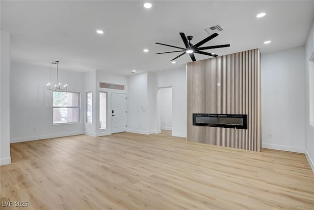 2353 Lauren Dr, Las Vegas, NV 89134 - unfurnished living room with a chandelier, a glass covered fireplace, light wood-type flooring, recessed lighting, and ceiling fan