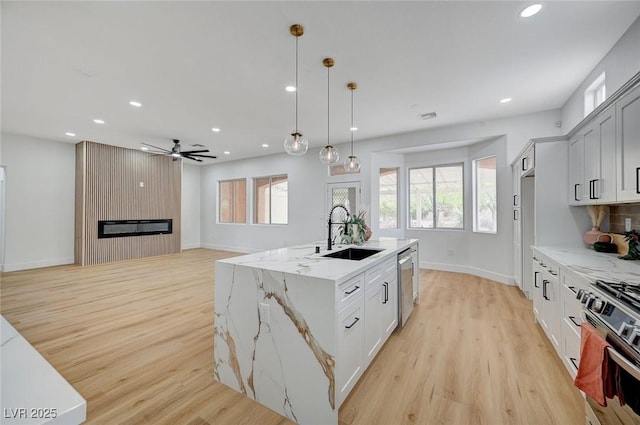 2353 Lauren Dr, Las Vegas, NV 89134 - kitchen with appliances with stainless steel finishes, recessed lighting, light wood finished floors, a fireplace, and hanging light fixtures