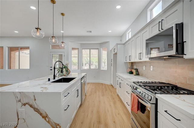 2353 Lauren Dr, Las Vegas, NV 89134 - kitchen with appliances with stainless steel finishes, light wood-style floors, tasteful backsplash, an island with sink, and recessed lighting