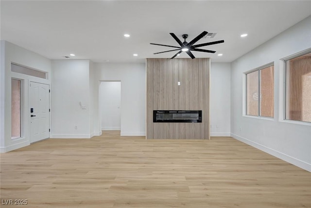 2353 Lauren Dr, Las Vegas, NV 89134 - unfurnished living room with light wood-style flooring, recessed lighting, a glass covered fireplace, and ceiling fan