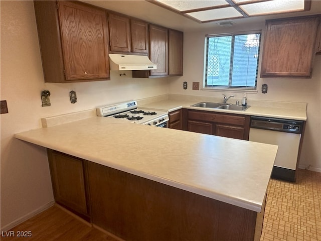 5199 Caliente St Unit 64, Las Vegas, NV 89119 - kitchen with white appliances, custom exhaust hood, a sink, baseboards, and a peninsula
