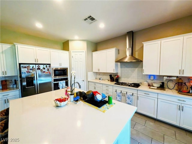 6021 Vivanco St, North Las Vegas, NV 89081 - kitchen with stainless steel appliances, wall chimney range hood, decorative backsplash, light countertops, and white cabinets