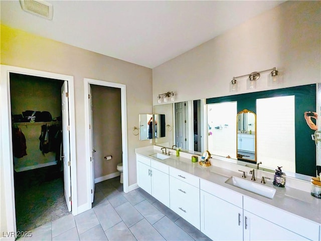 6021 Vivanco St, North Las Vegas, NV 89081 - full bathroom featuring tile patterned floors, double vanity, and a walk in closet