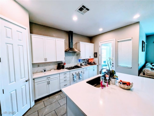 6021 Vivanco St, North Las Vegas, NV 89081 - kitchen with wall chimney exhaust hood, decorative backsplash, white cabinets, light countertops, and light tile patterned floors