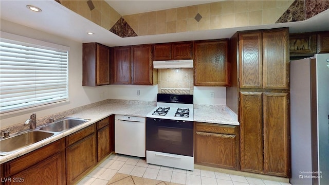 4998 Schumann Dr, Las Vegas, NV 89146 - kitchen featuring fridge, gas range oven, a sink, under cabinet range hood, and light countertops